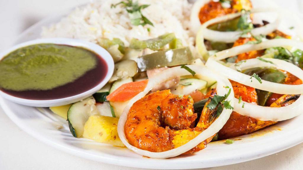 Tandoori Prawns · Jumbo prawns marinated in a special blend of spices and herbs then roasted in the tandoor. Served with sliced onions and lemons.