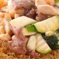 Hk Style Crispy Noodles · Crispy pan fried noodle topped with a light garlic sauced combination of chicken, beef, shri...