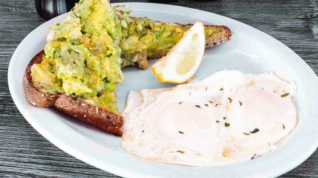 Avocado Toast · A thick cut piece of wheat toast covered in fresh avocado. Served with lemon & two basted eggs