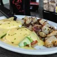 Avocado Benedict · Grilled English muffin topped with fresh sliced tomato, avocado, two poached eggs* & holland...