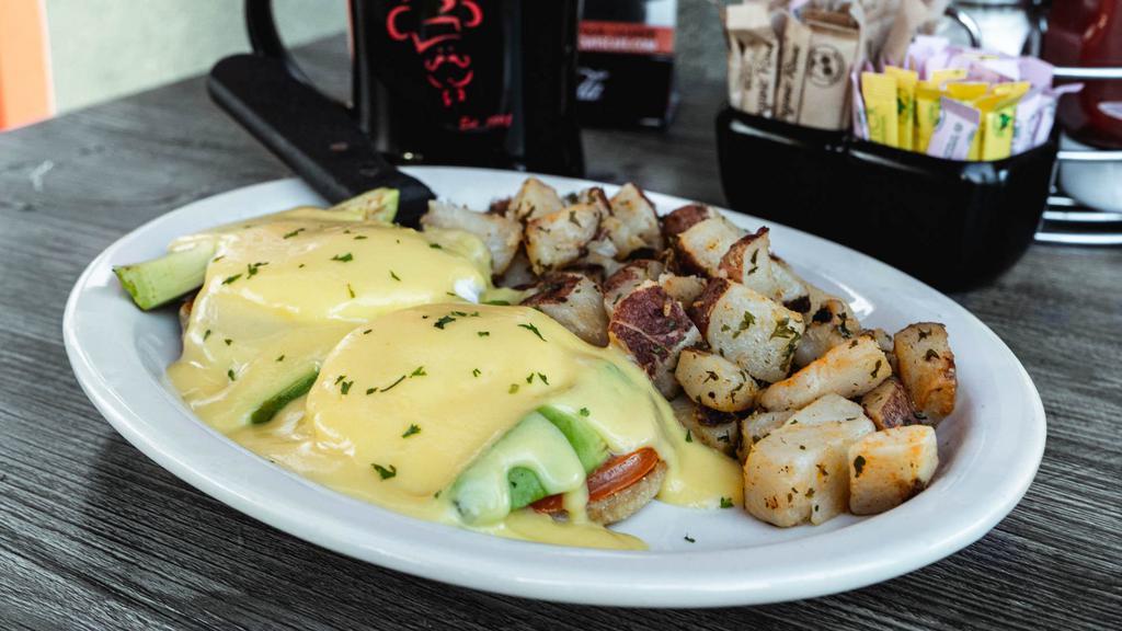 Avocado Benedict · Grilled English muffin topped with fresh sliced tomato, avocado, two poached eggs* & hollandaise sauce.