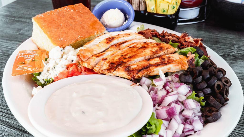 Cobb Salad · Fresh greens topped with grilled chicken strips, diced bacon, tomato, boiled egg, black olives, red onions & blue cheese crumbles. Your choice of dressing.