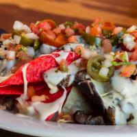 Sonrisa Nachos · House fried chips with refried beans, white queso sauce, topped with pico de gallo and pickl...