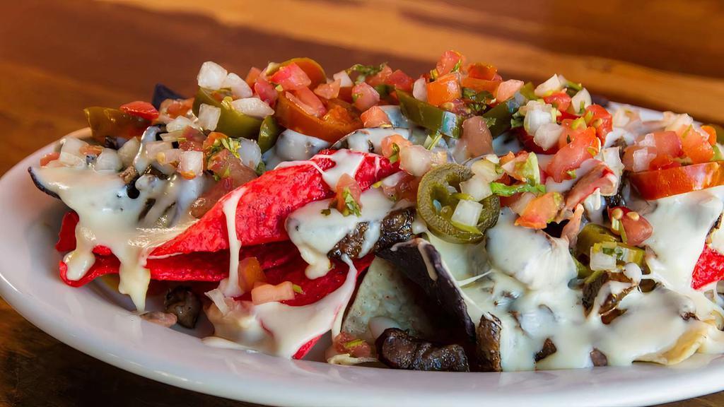 Sonrisa Nachos · House fried chips with refried beans, white queso sauce, topped with pico de gallo and pickled jalapenos.