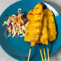 Chicken Satay · Grilled chicken skewers marinated with coconut milk and turmeric, served with sliced cucumbe...