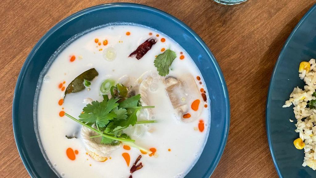 Tom Kha · Coconut milk sour soup with Thai chili paste, galangal, kaffir lime leaf, lemongrass, mushroom, tomato, lime juice, topped with green onion and cilantro.