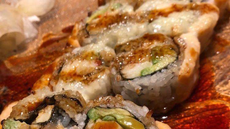 Alaska King Crab Roll · King crab and avocado topped with salmon and garlic butter, baked and served with eel sauce.
