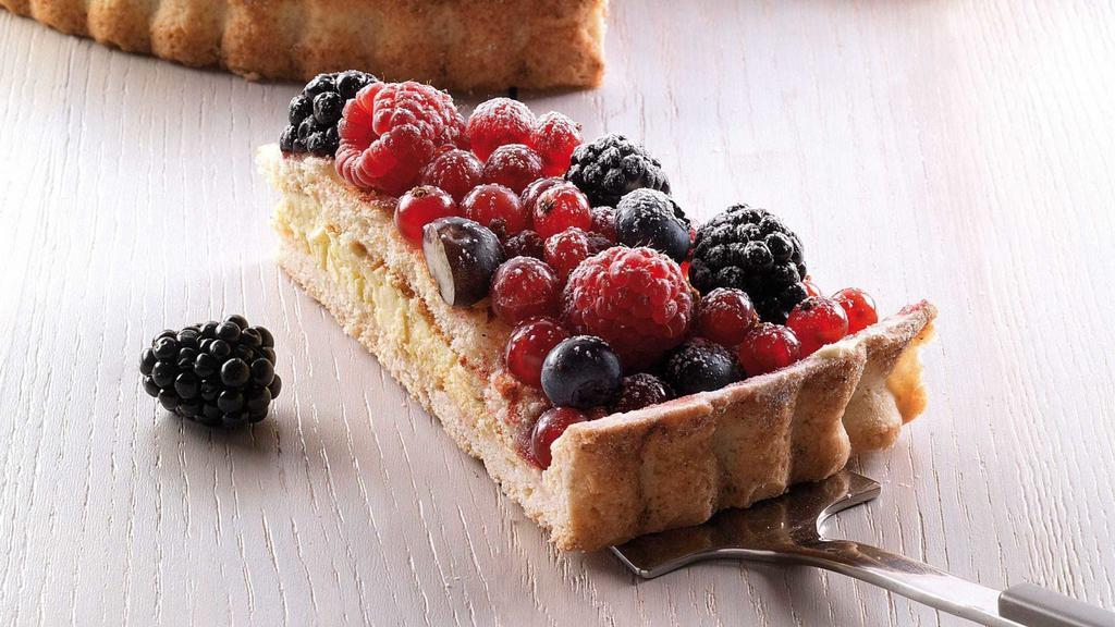 Mixed Berry Tart · Short crust pastry base filled with pastry cream, topped with a layer of sponge cake and lavishly garnished with an assortment of berries:  blackberries, blueberries, raspberries, red currants and strawberries.