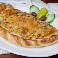 The Greek Calzone · Onions, Greek feta cheese, Greek olives & gyro meat with a side of homemade tzatziki sauce (...
