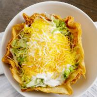 Chicken Taco Salad · Chicken, beans, lettuce, sour cream, guacamole, pico de gallo, and cheese on a taco shell.
