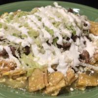 Chilaquiles · Fried tortillas mixed with a spicy sauce, eggs, lettuce, sour cream , onions and cheese with...