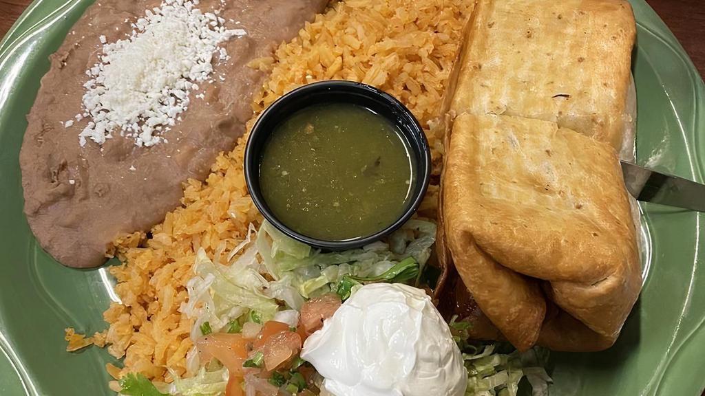 Chimichanga Online · Filled with your choice of meat, cheddar and cotija cheese, pico de gallo, lettuce and sour cream. Topped with our spicy green sauce. Served with rice and beans