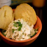 Reina Pepiada Arepa · Shredded cold chicken breast salad served on a bed of mixed greens, topped with crema queso ...