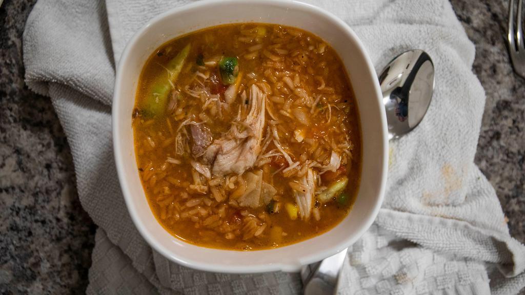 Chicken Tortilla Soup · Traditional Mexican soup made with rich chicken broth and shredded chicken and vegetables, topped with fried crispy corn tortilla strips and avocado pieces.
