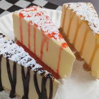 New York Style Cheesecake · Creamy Cheesecake With a Graham Cracker Crust. Served. With Your Choice of Chocolate, Strawb...