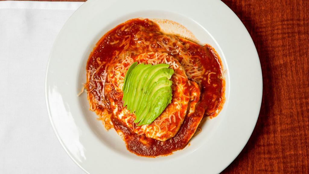 Huevos Rancheros · Corn tortillas layered with refried beans, two over easy eggs, melted jack cheese and our signature Spanish sauce, topped with avocado.
