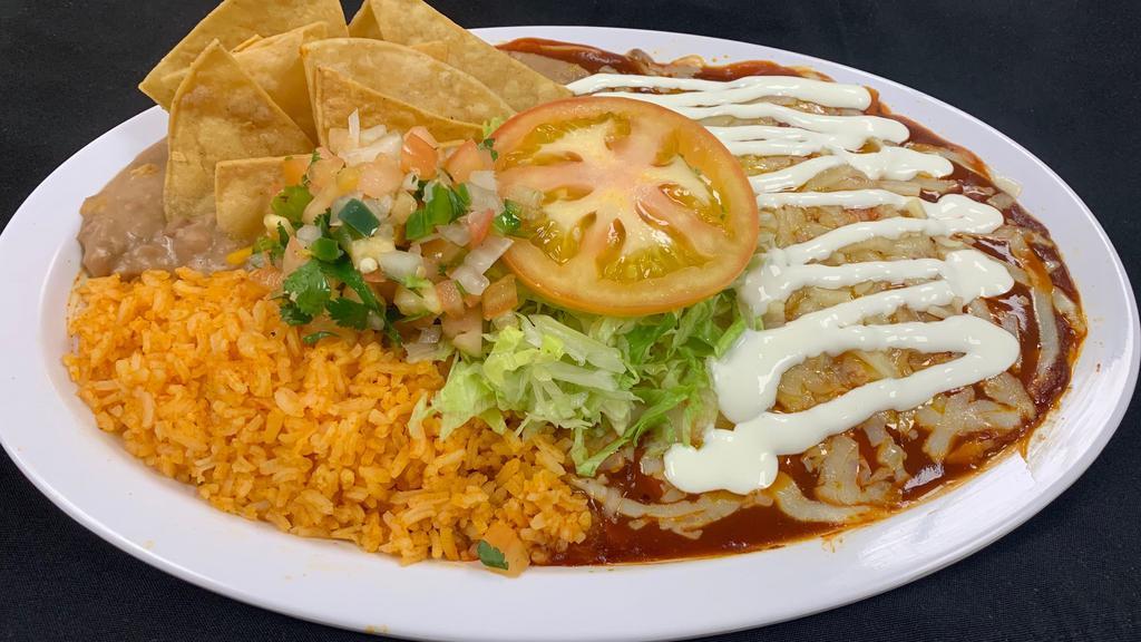 2 Enchiladas W/Rice & Beans · 2 Enchiladas with choice of meat, smothered in mild red salsa and cheese, rice, beans, lettuce, tomato, sour cream and chips