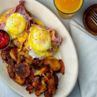 Traditional Eggs Benedict · Top menu item. Grilled English muffin, shaved smoked ham and two poached eggs. Topped with o...