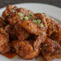 Chili Marinated Hot Wings · Fried hot wings tossed in a spicy, sweet garlic sauce. Served with a side of pickled radishes.