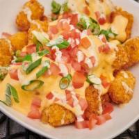 App - Carne Asada Tots · Signature cheese blend, tomato, green onion, and bacon, topped with garlic aioli.