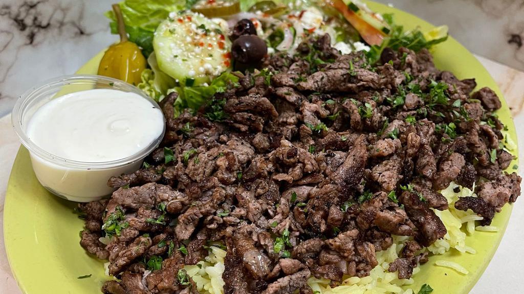 Lamb Shawarma Plate · Thinly sliced marinated boneless lamb mixed with our special spices - served with salad rice & pita