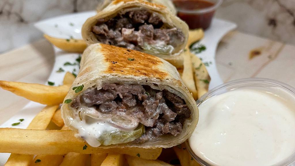 Beef Shawarma Wrap · Beef shawarma wrapped with tortilla bread with pickle onion tomato & garlic sauce - served with fries