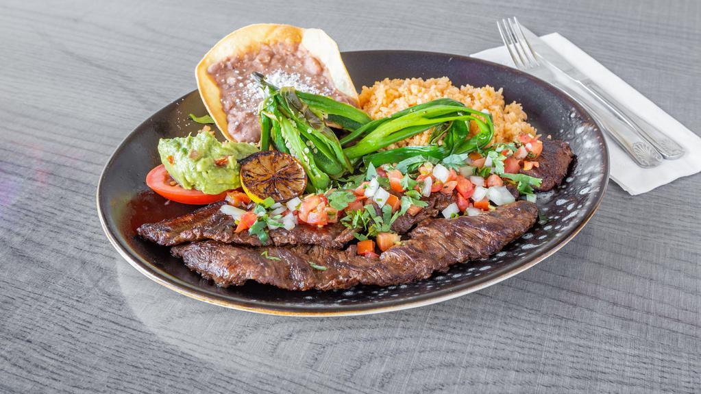 Carne Asada Plate *Gf · Skirt steak cooked to perfection, served with
green onions, lightly fried jalapeño, pico de
gallo, topped with guacamole