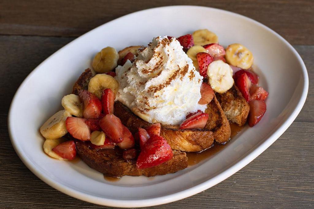 Fabulous French Toast · Thick cut brioche, fresh strawberries & bananas, caramelized brown sugar butter sauce, lots of real whipped cream.