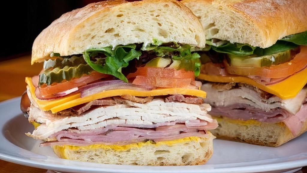 Club Tasty · HH roasted all natural turkey breast, Zoe's Black Forest ham and thick sliced bacon, sharp cheddar cheese, mix greens, tomato, pickle, red onion, mayo, and mustard on a demi baguette.