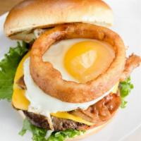 Supersonics · 1/4 lb Natural Beef Patty, 2 strips of bacon, fried egg, american cheese topped w/ onion rin...