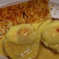 Traditional Benedict · A grilled English muffin topped with Canadian bacon, two poached eggs & topped with fresh ho...