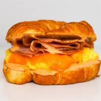 Croissant, Turkey Ham, Egg, & Cheddar Sandwich · 2 scrambled eggs, melted Cheddar cheese, sliced turkey ham, and Sriracha aioli on a warm cro...