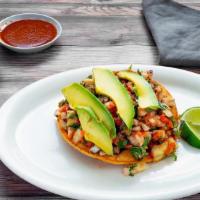 Tostada De Fish Ceviche · Fresh white fish marinated in lime juice mixed with cilantro, chopped onions and diced carro...