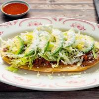 Huarache · Oval homemade corn masa shell topped with refried beans your choice of chicken, ground beef ...