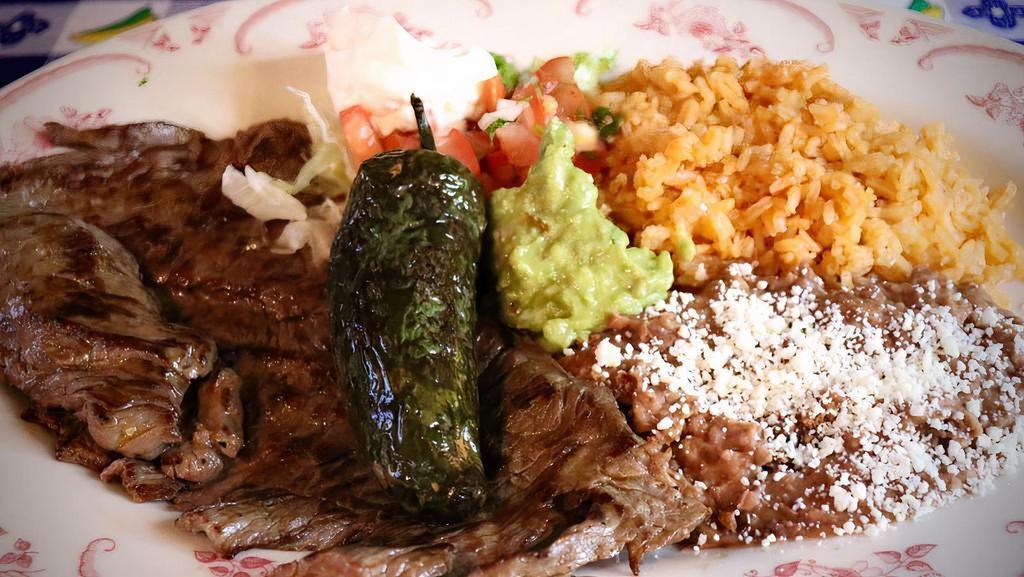 Carne Asada · Grilled skirt steak served with rice, beans, sour cream and guacamole.