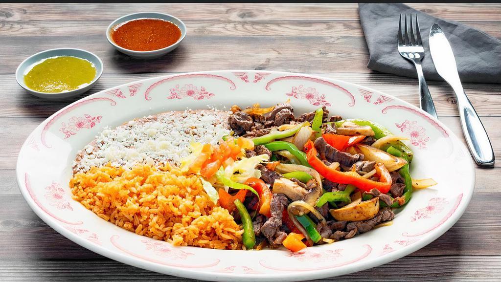 Carnitas De Res · Steak strips cooked and mixed with onions, mushrooms, bell pepper, and tomato. Served with rice and beans.