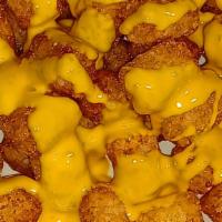Nacho Cheese Tots · Basket of deep fried tater tots drizzled with nacho cheese