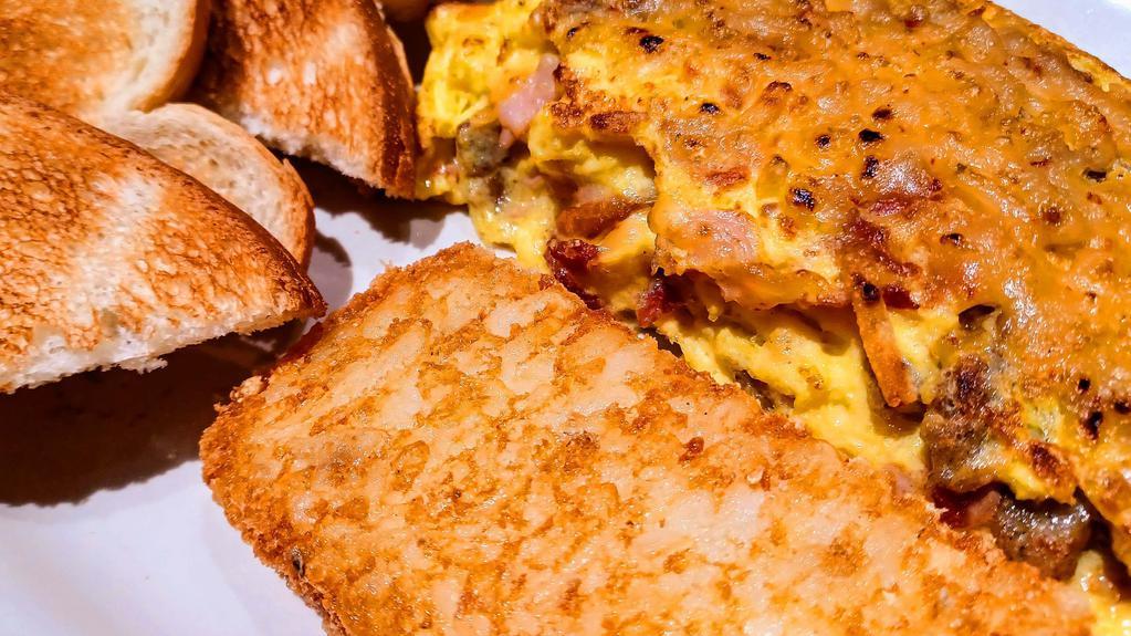 Meat Lovers Omelette Combo · 3 egg omelette filled with ham, bacon and sausage topped with cheddar and pepper-jack cheese served with sausage patties or bacon strips, a deep fried hash brown patty or country potatoes and your choice of toast.
