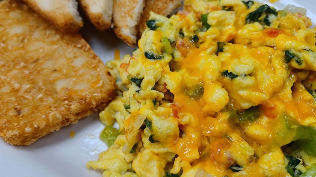 Veggie Scramble · 3 eggs scrambled with spinach, onions, tomatoes, bell peppers and your choice of cheese, choice of toast and choice of either country potatoes or a patty of hash browns.