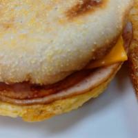 Turkey And Egg English Muffin · Toasted English muffin with sliced ham, scrambled eggs and your choice of cheese, served wit...