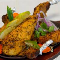 Whole Tandoori Chicken · Whole chicken stuffed/marinated with homemade masala’s and cooked in the oven.