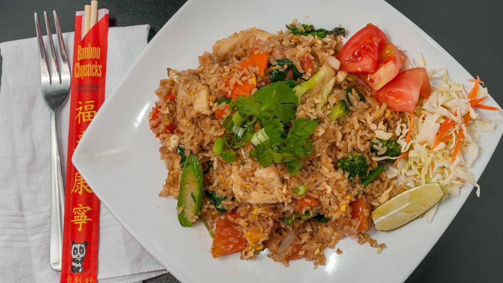 #25. Thai Fried Rice · Thai style fried rice, eggs, onions, tomatoes, carrots, and broccolies garnished with slices of cucumbers.