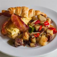 Croissant Breakfast Sandwich · 2 scrambled eggs, sausage, ham or bacon, with Swiss cheese sandwiched between a warm croissa...