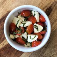 Caprese · Grape tomatoes, fresh mozzarella, basil, and extra virgin olive oil.