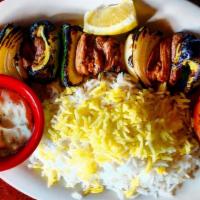 Babajoon'S Lamb Shish Kabob · Marinated tender lamb chunks with zucchini, onion, bell peppers. Comes with 1/2 a grilled to...