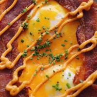 Breafkast · Our waffle topped w/two soft cooked eggs, melted cheddar, special smoked aioli, chives, your...