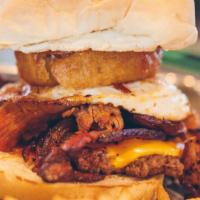 Sickies Burger · Peppered bacon, fried egg, pulled pork, BBQ sauce, American cheese, topped with onion rings ...