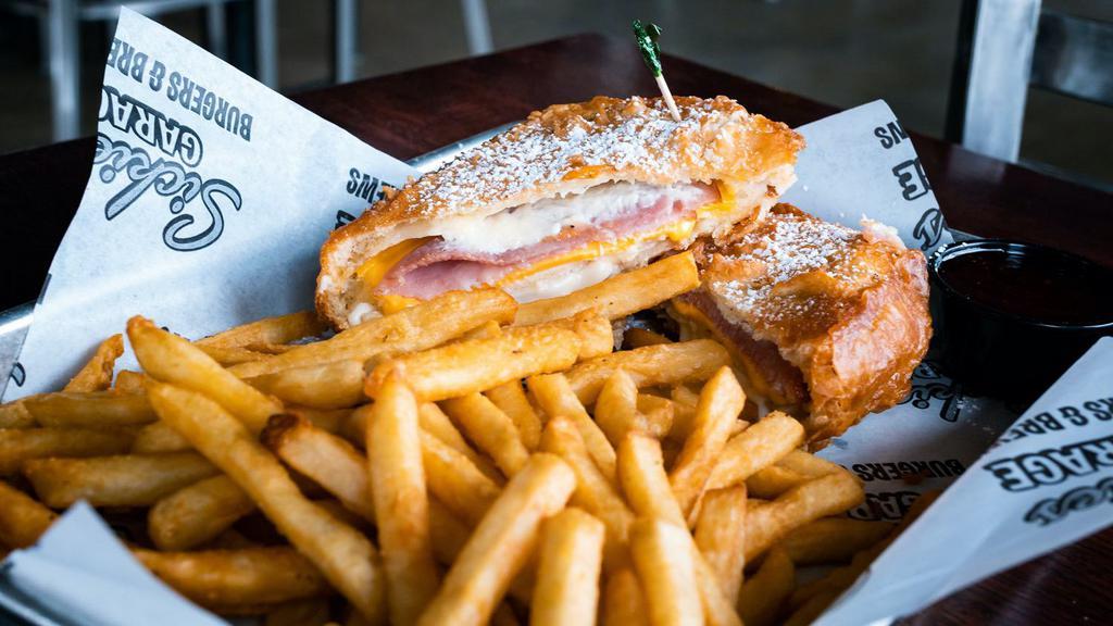 Monte Cristo · Bread layered with tender ham, roasted turkey, Swiss and American cheeses, and mayo. Batter-dipped, gently fried, and coated with powdered sugar. Served with red raspberry preserves for dipping.