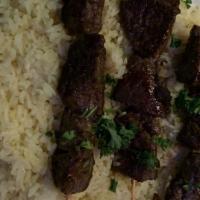 Lamb Kebab · Tender marinated lamb. Two skewers served on a bed of our special flavored rice, with homema...