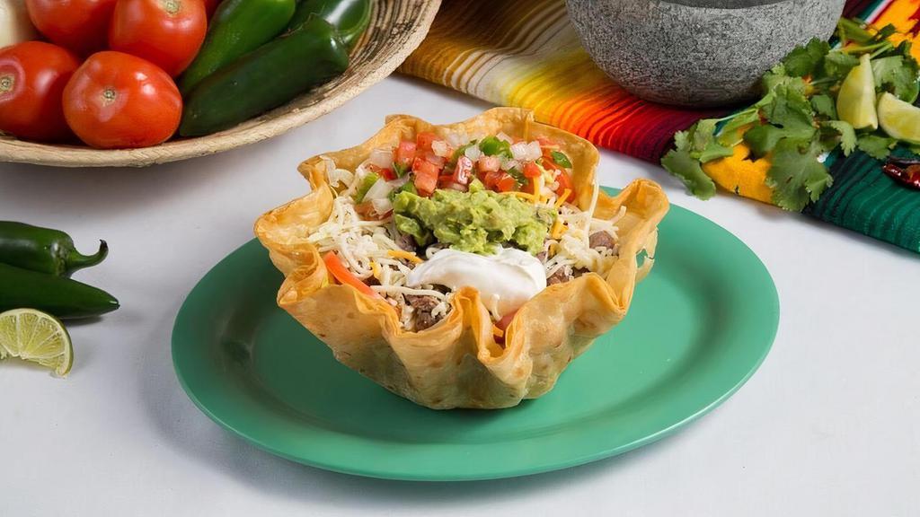 Taco Salad · Crispy taco shell filled with lettuce, beans, cheese, choice of meat, topped with sour cream, guacamole, and fresh pico de gallo salsa